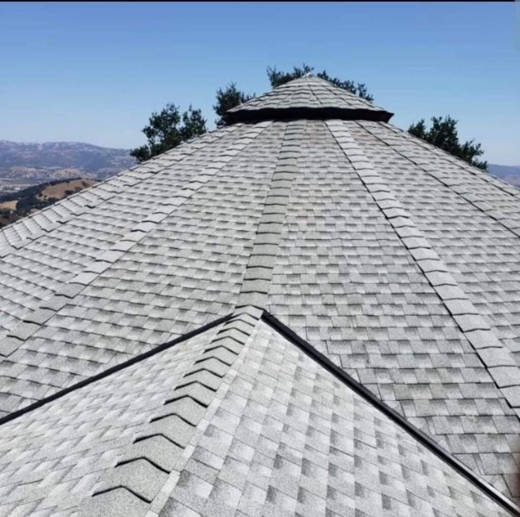 Quality asphalt roofing shingles installed on a residential house for durability and weather protect.